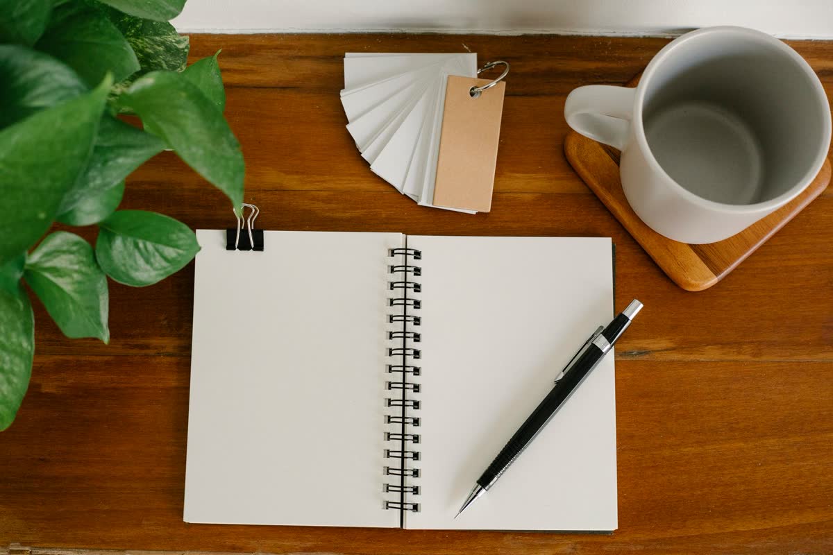 An open blank notebook with a pencil on a wooden desk, for keeping records after a car accident