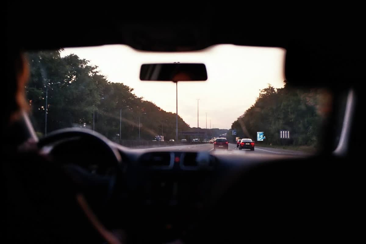 View through a car windshield on a busy road at dusk, a typical commute where fender-benders happen