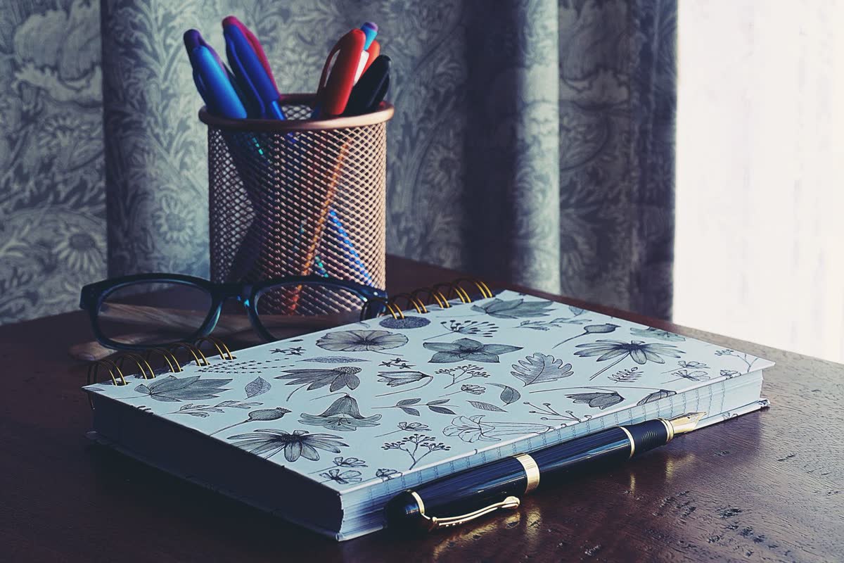 An open journal and pen on a desk, for keeping notes in the days after a car accident