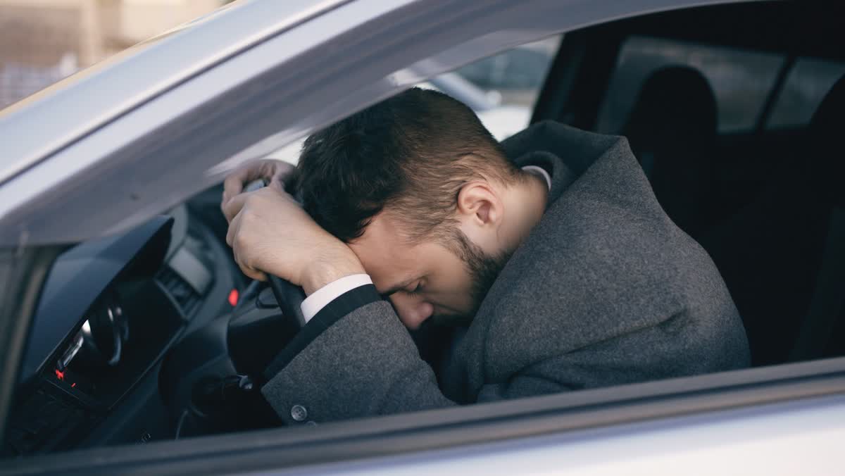 Shaken driver resting his head on the steering wheel