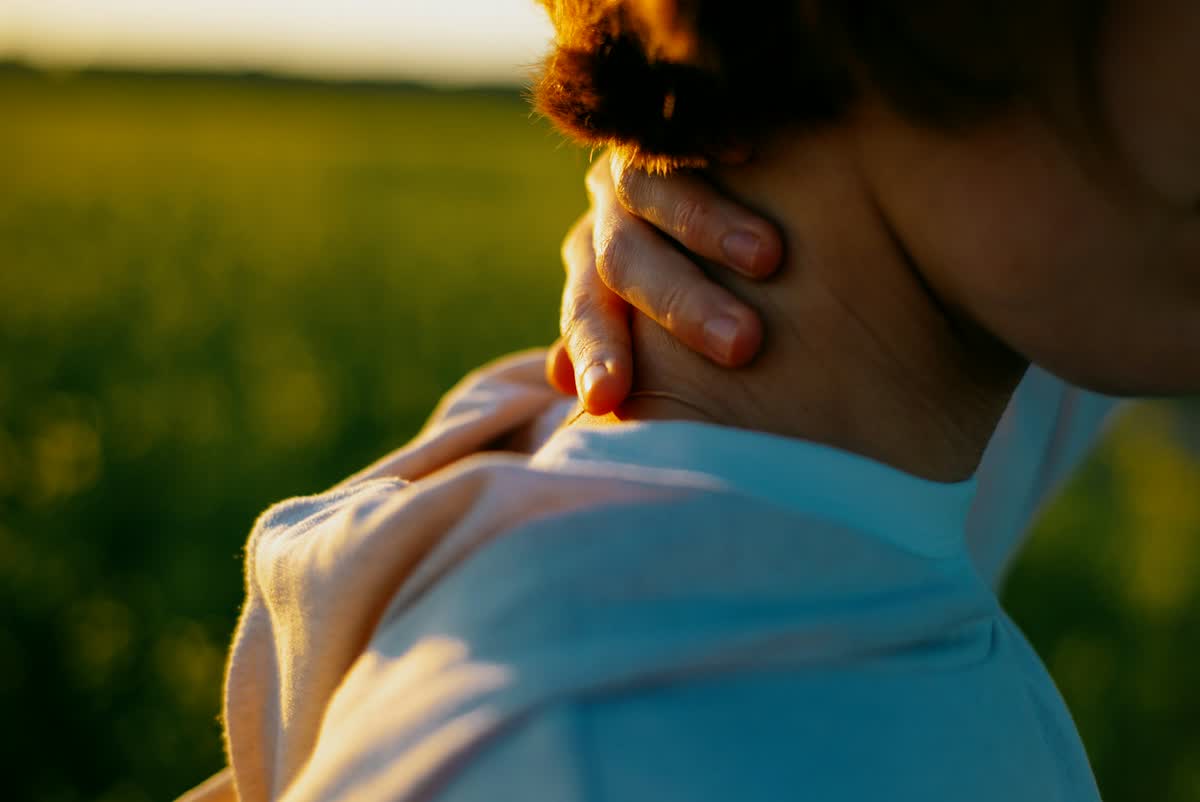 Woman holding the back of her sore neck